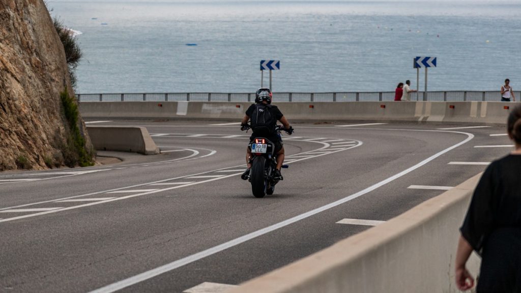 Motocicleta circulando por una carretera costera