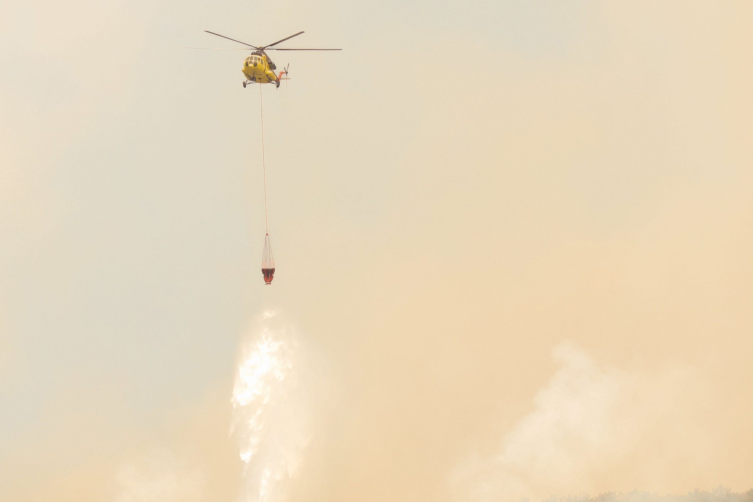 Imagen de recurso de un helicóptero descargando agua sobre un incendio forestal
